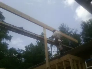 Carpenter setting a ridge beam over a new addition frame — Ice Dam Removal by Roofing Brothers in Folly Beach