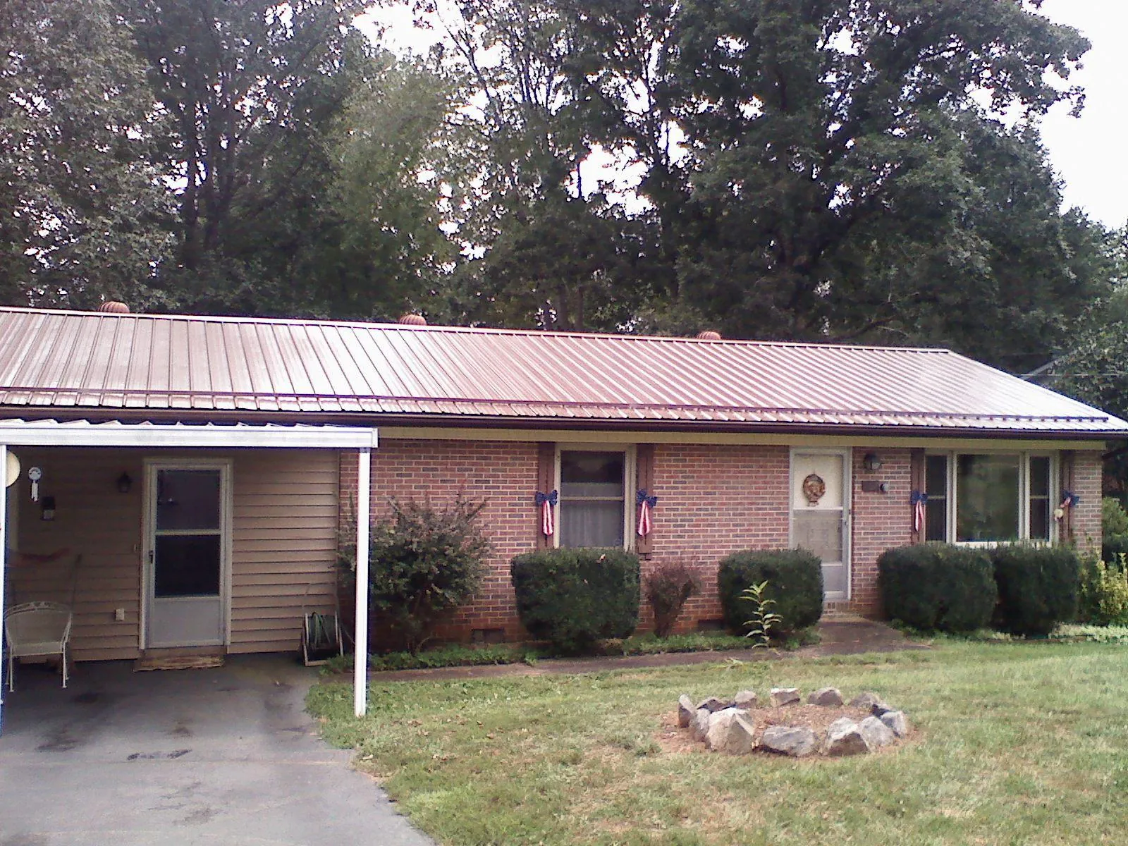 Bronze metal roof and carport on a brick ranch home — Roof Repair work by our crew in Folly Beach